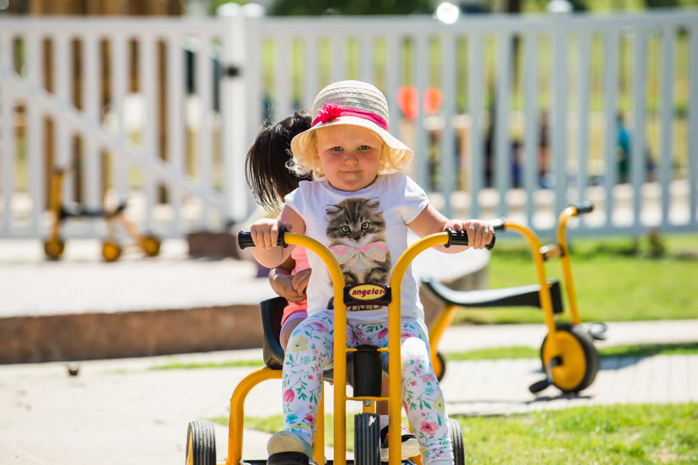 child riding tricycle at Guidepost Montessori